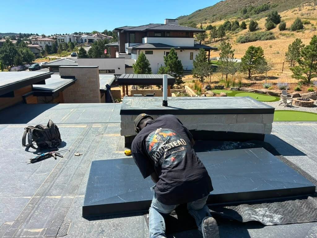 A new cap going on at a Parker home on the Palmer Divide, where downslope wind off the Front Range presses down on any chimney that terminates too low.