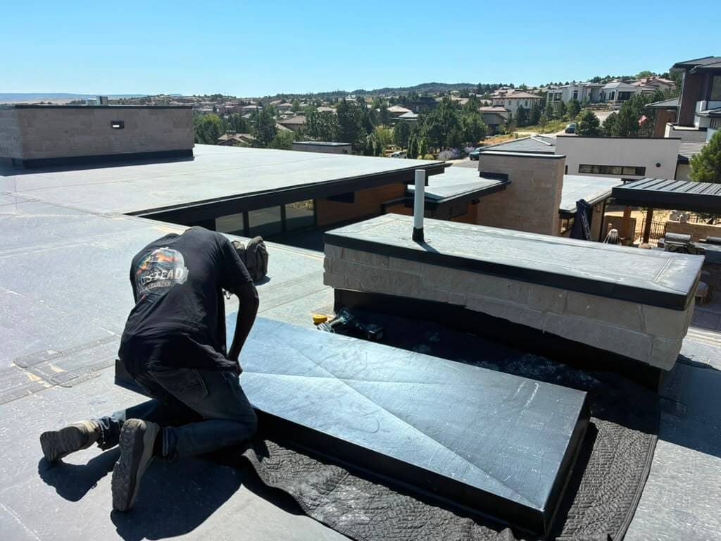 Cutting and shaping a metal chase cover to fit a chimney chase on a Colorado rooftop