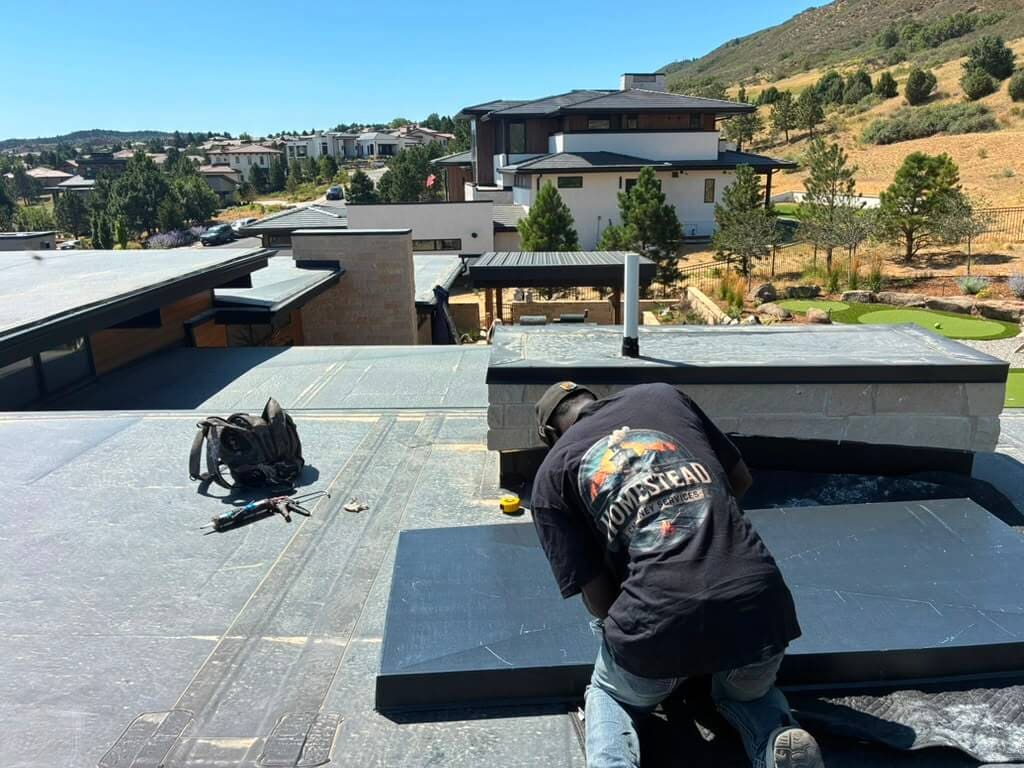 Parker Homestead Chimney crew member on a rooftop chimney job with Colorado foothills views